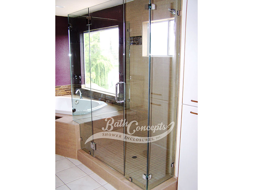 26 Frameless corner enclosure with door hinged off the inline stationary panel & an extra stationary inline panel & 2 return panels CLEAR GLASS CHROME HARDWARE 1193 - 1293